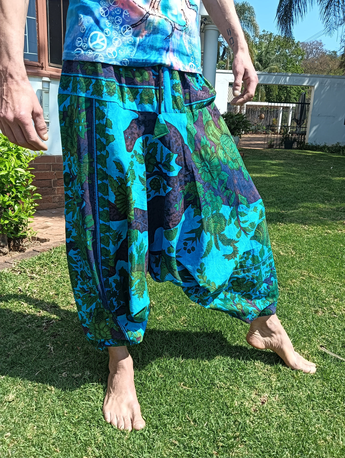 Tropical Print Aladdin Harem Pants in Teal Blue — front view showing drape