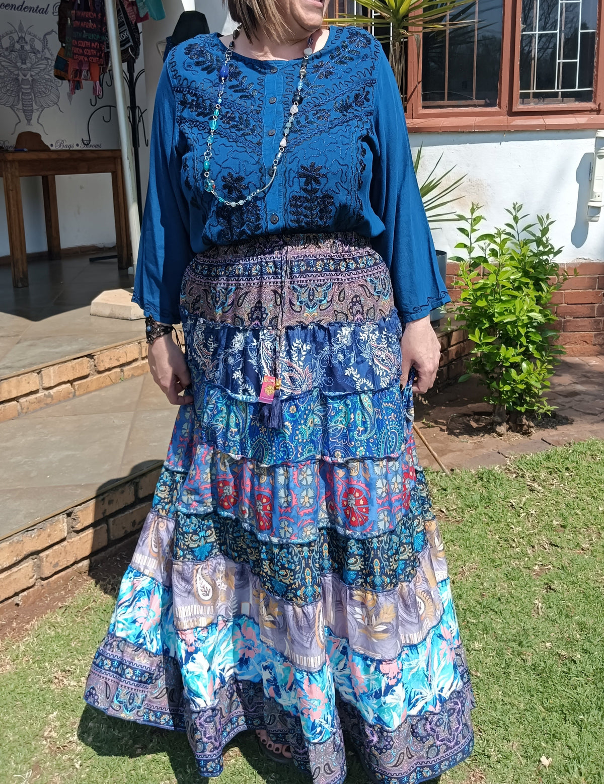 Gypsy Tiered Maxi Skirt styled with Embroidered Viscose Blouse – three-quarter view showing full skirt sway