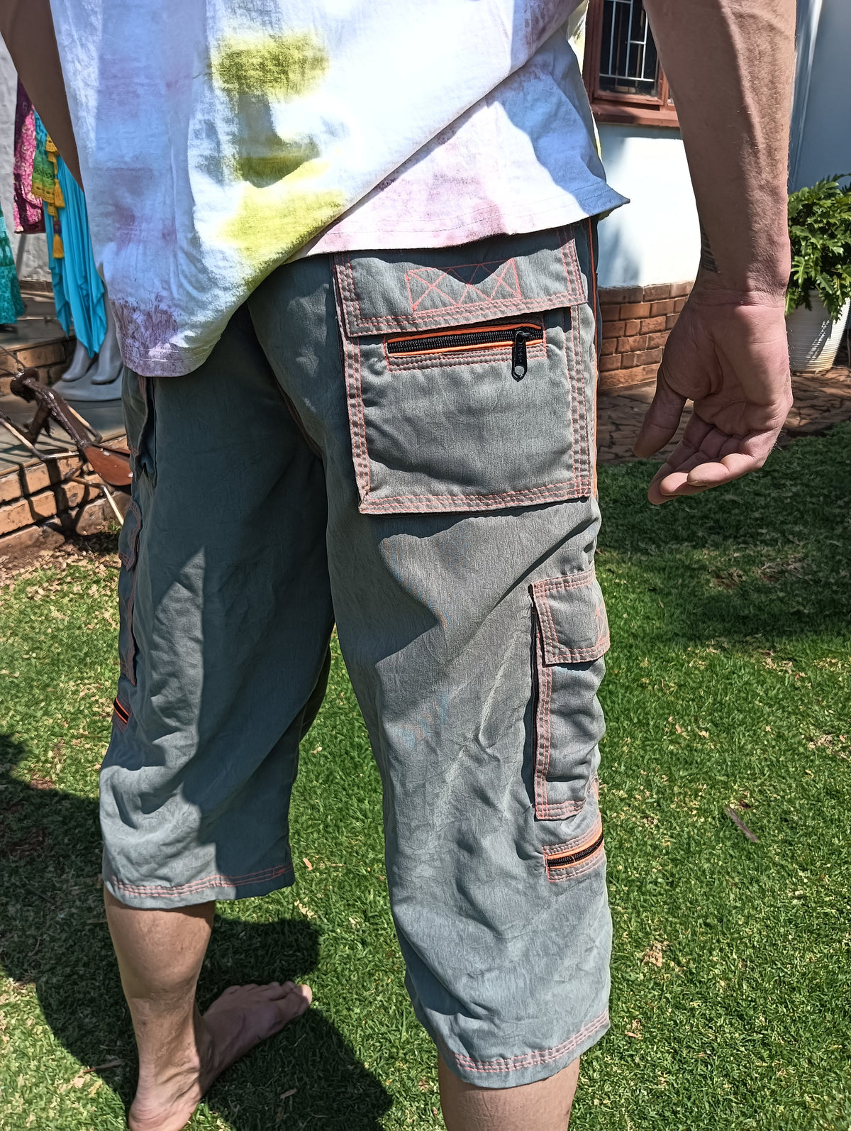 Stone-Washed Cargo 3/4 Shorts in Grey and Neon Orange – close-up of hip cargo pocket showing zip and quilted flap detail