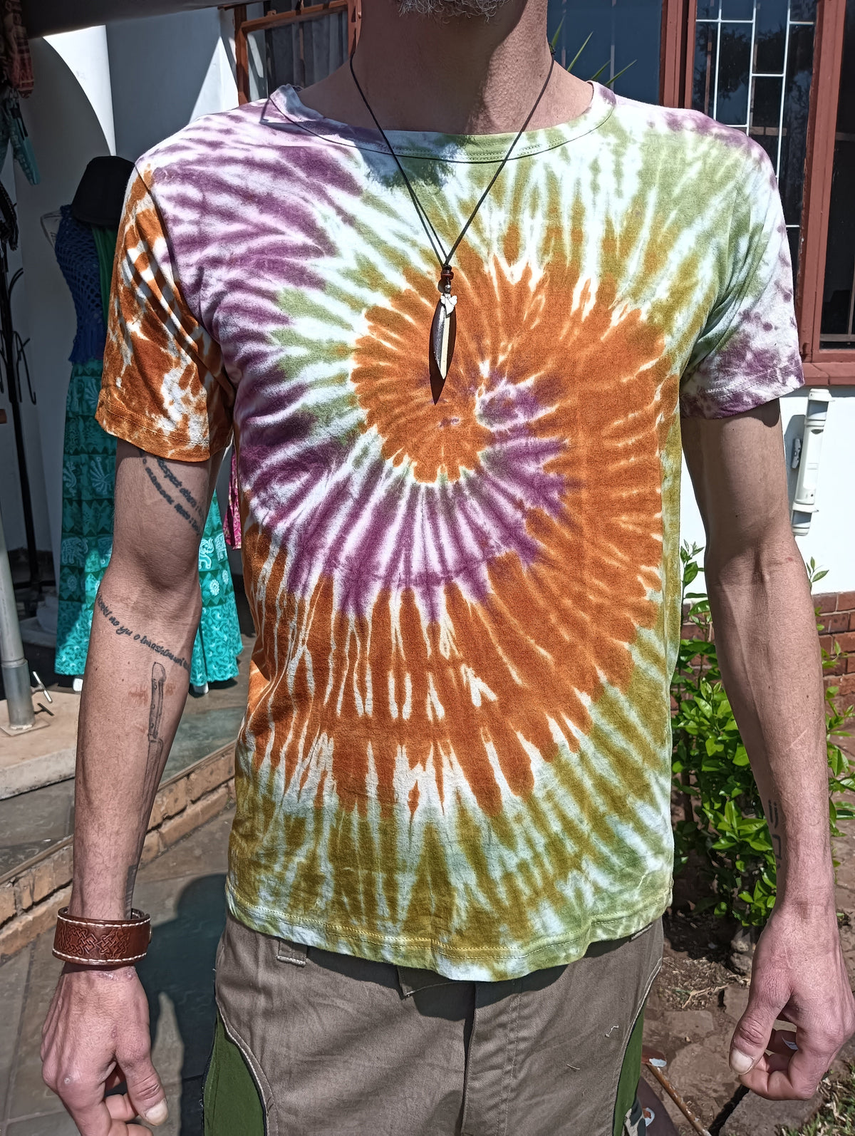 Hand Tie-Dye Spiral T-Shirt in Orange Lavender Olive – front view on male model showing full spiral dye pattern