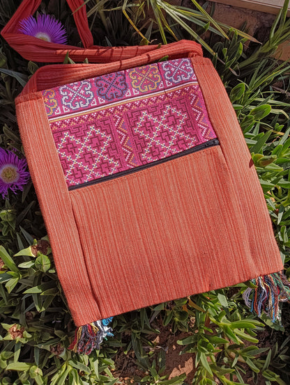 Thai Woven Sling Bag in Burnt Orange — back view showing zip pocket and tassel fringe
