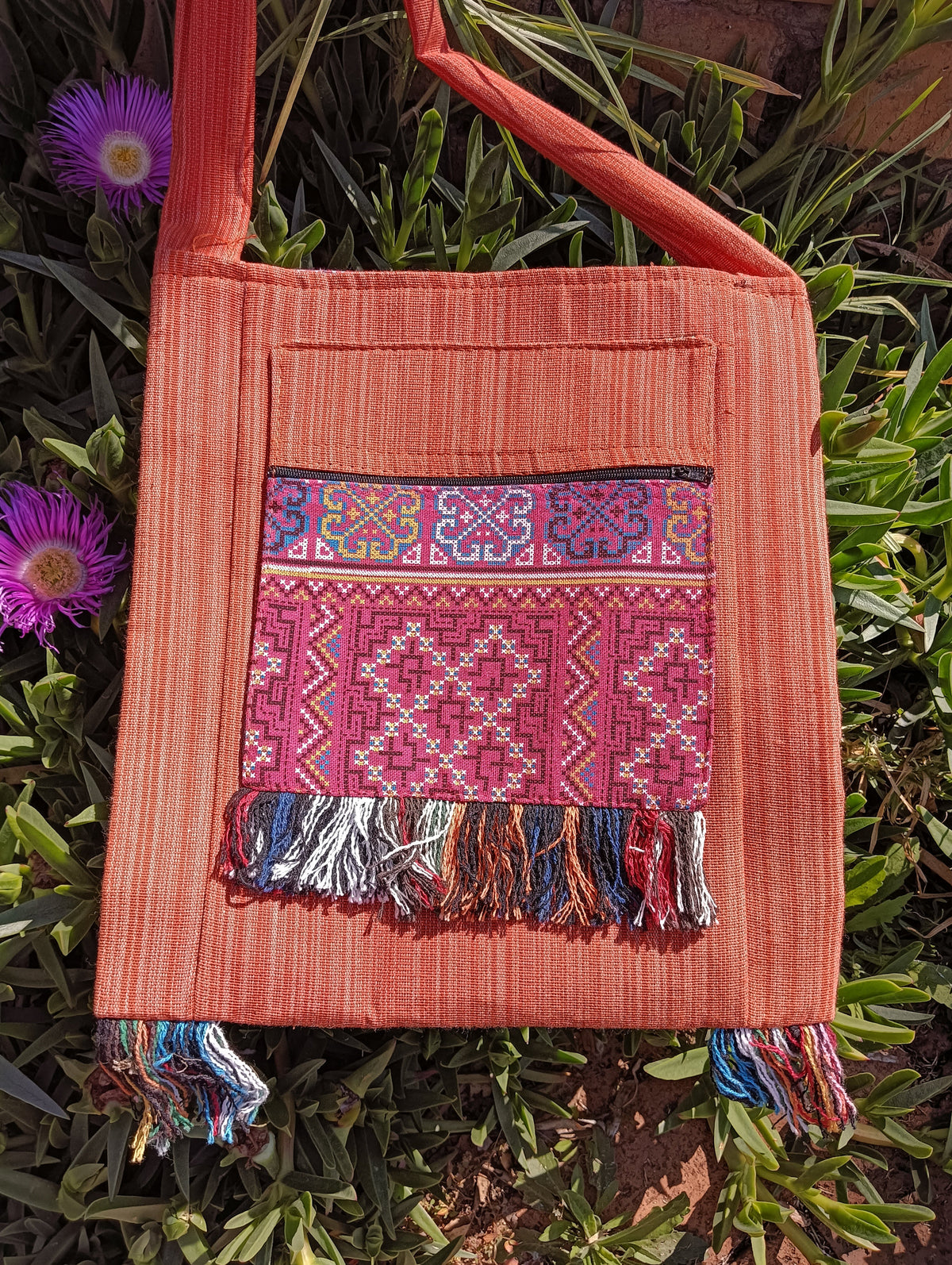 Thai Woven Cotton Sling Bag Terracotta Pink Floral Border – front view showing pink cross-stitch geometric panel with zip and multicolour fringe