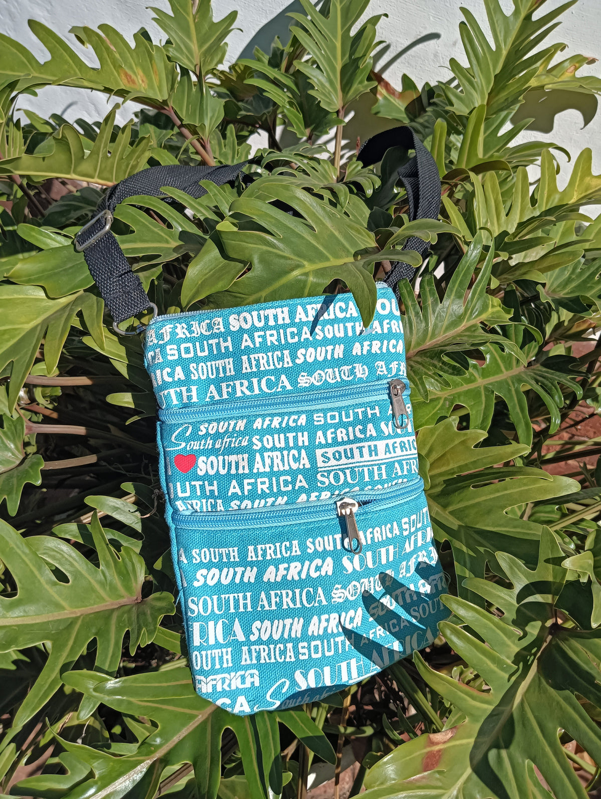 South Africa Print Canvas Bag in Teal — front view showing all-over text print and double zip pockets