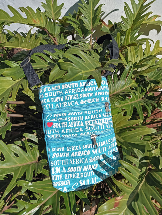 South Africa Print Canvas Bag in Teal — front view showing all-over text print and double zip pockets