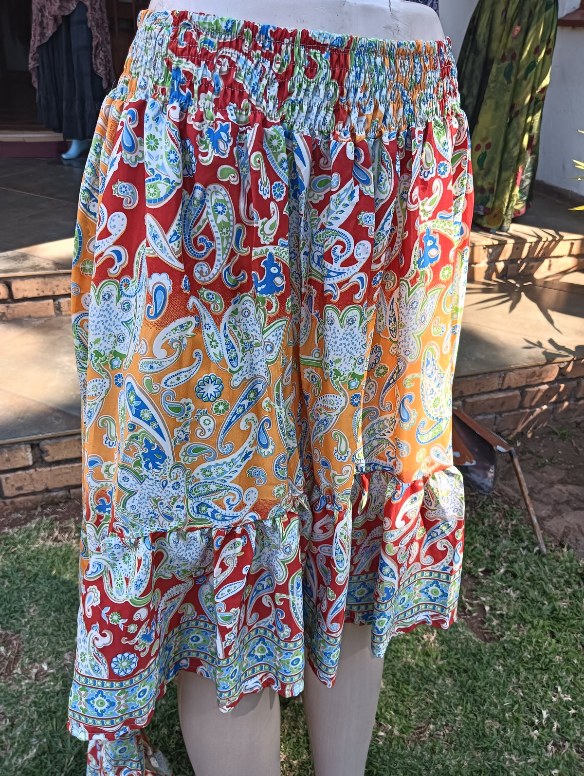 Paisley Poly Silk Hi-Low Frill Skirt in Red Orange — front view on mannequin